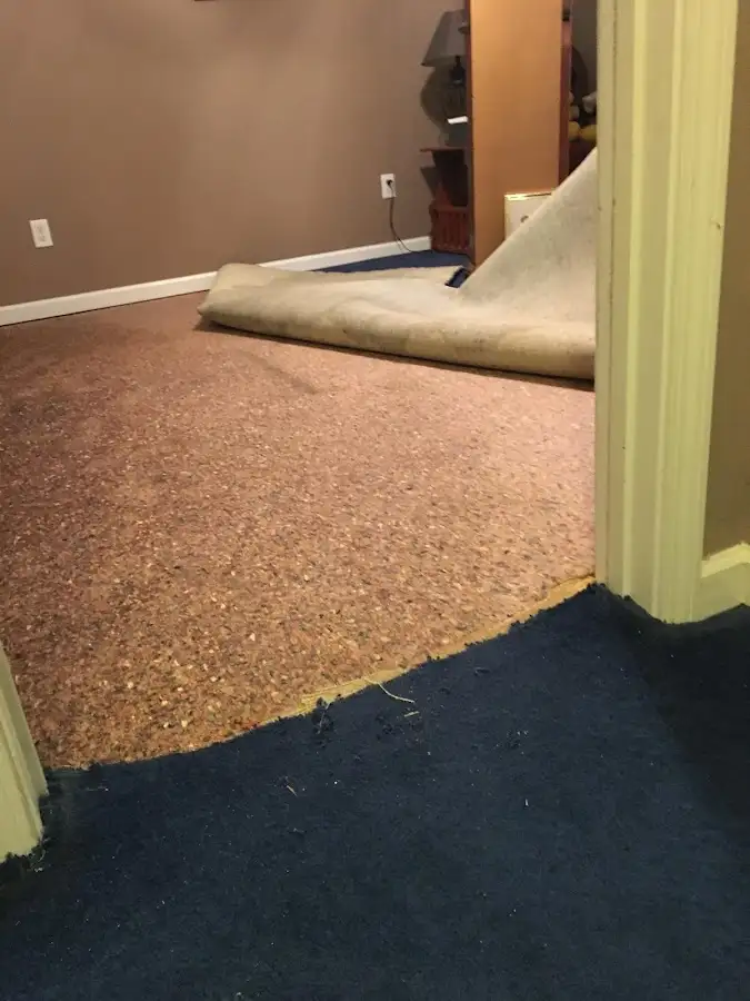 Carpet pad removal revealing water damage during Water Mitigation Services in Tomball